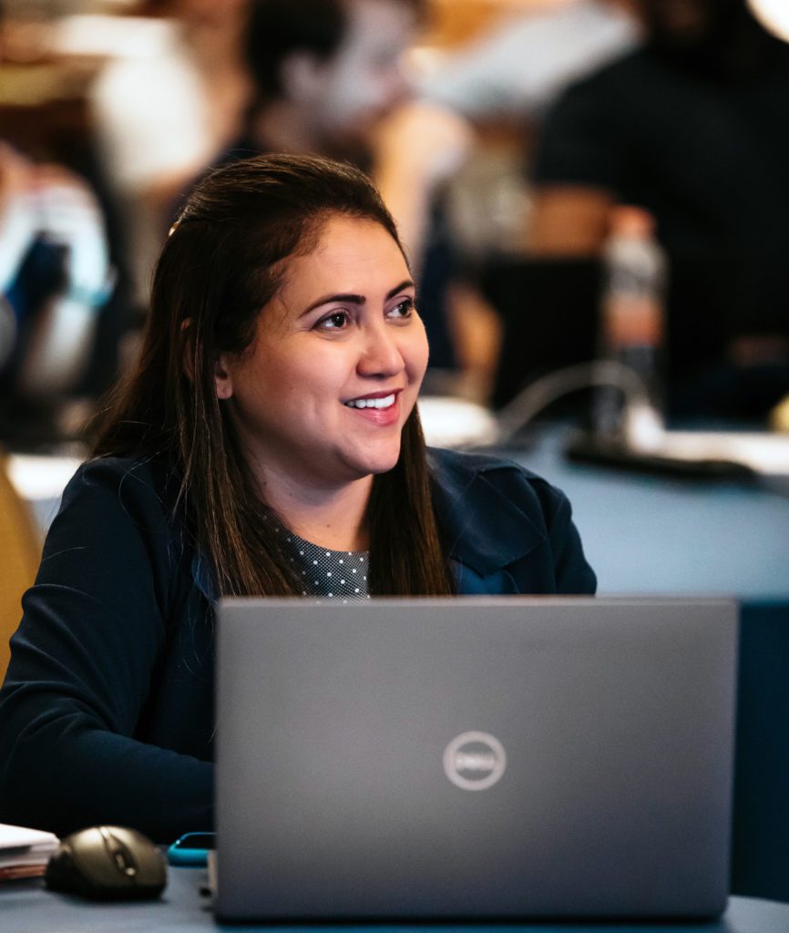 Latina woman with laptop smiling